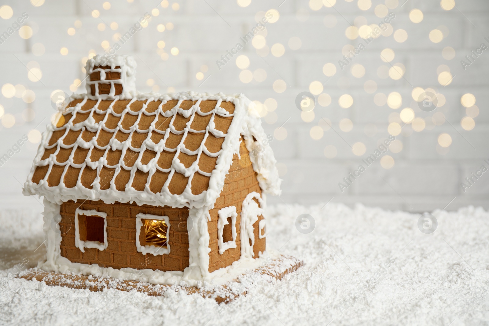 Photo of Beautiful gingerbread house decorated with icing on snow, space for text