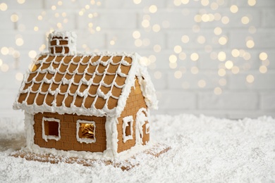 Photo of Beautiful gingerbread house decorated with icing on snow, space for text