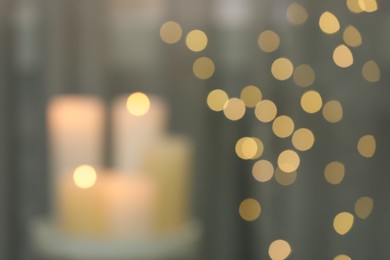 Photo of Blurred view of burning candles indoors. Bokeh effect