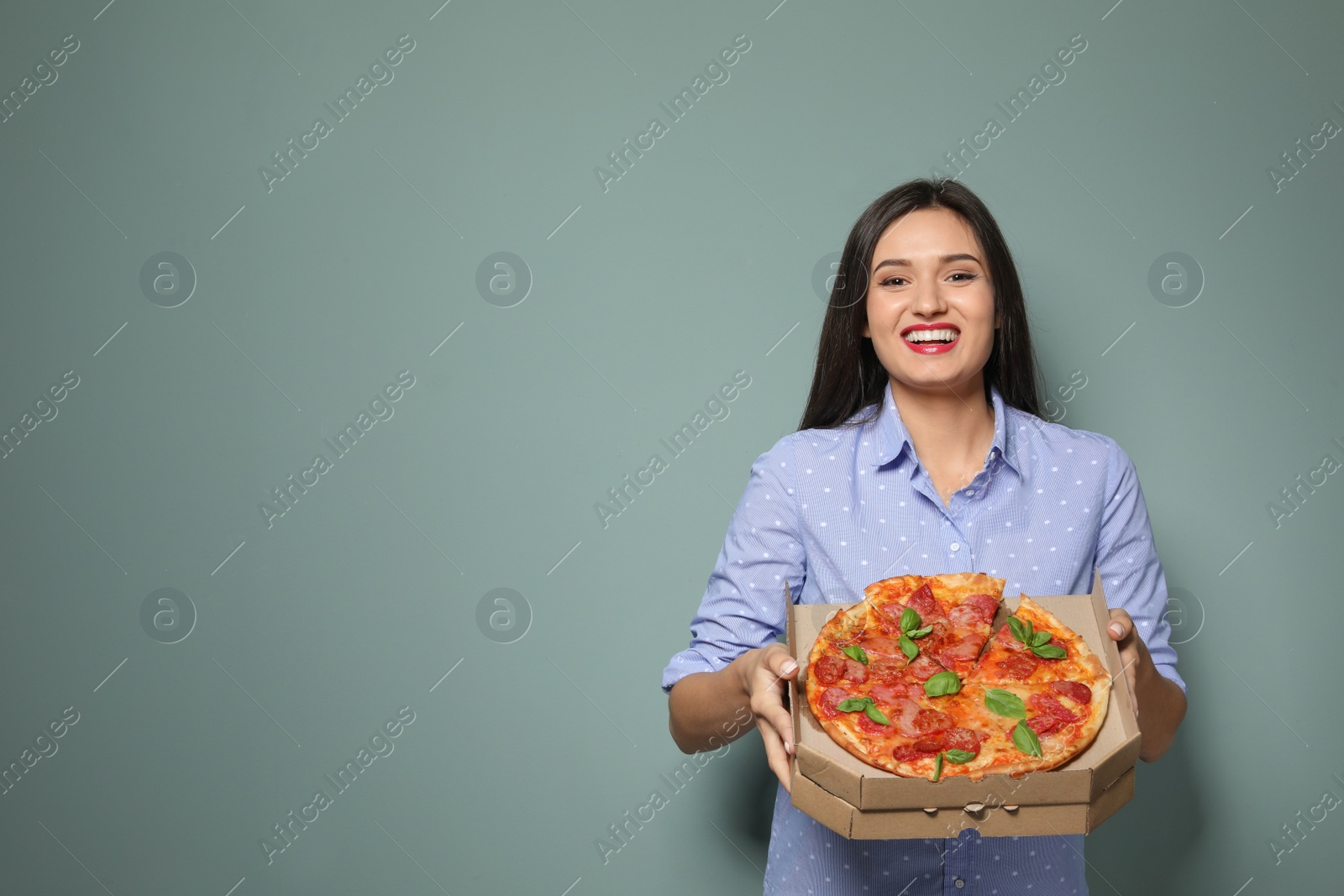 Photo of Attractive young woman with delicious pizza on color background