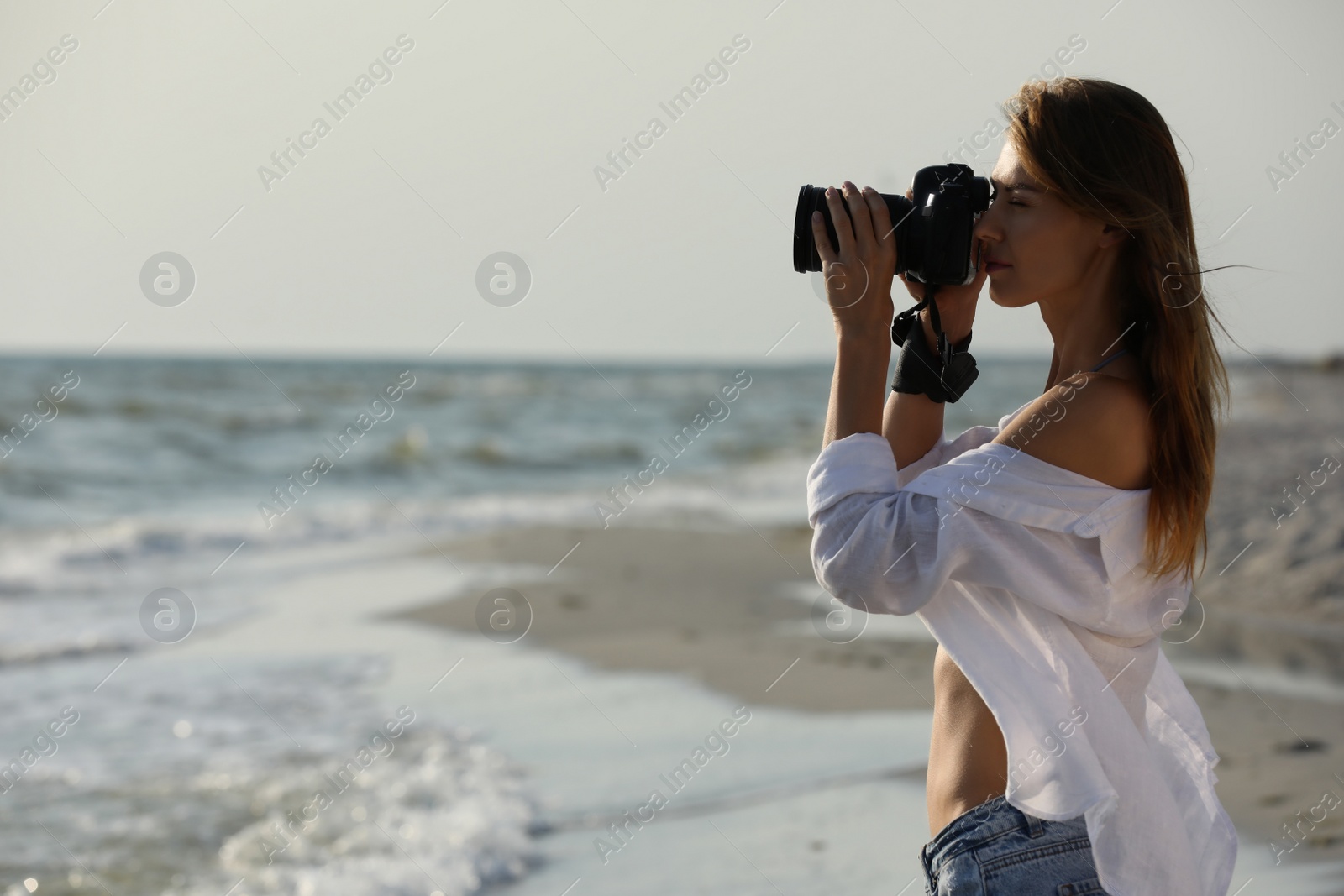 Photo of Photographer taking photo with professional camera near sea