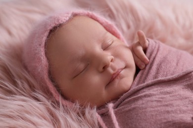 Photo of Adorable newborn baby lying on faux fur, closeup
