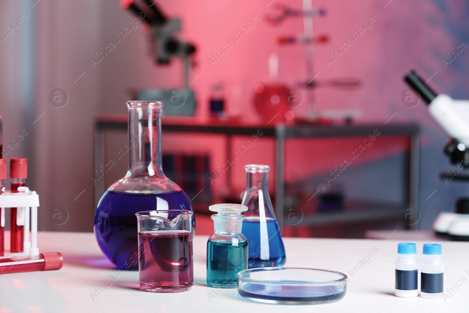 Photo of Different glassware with samples on table in chemistry laboratory