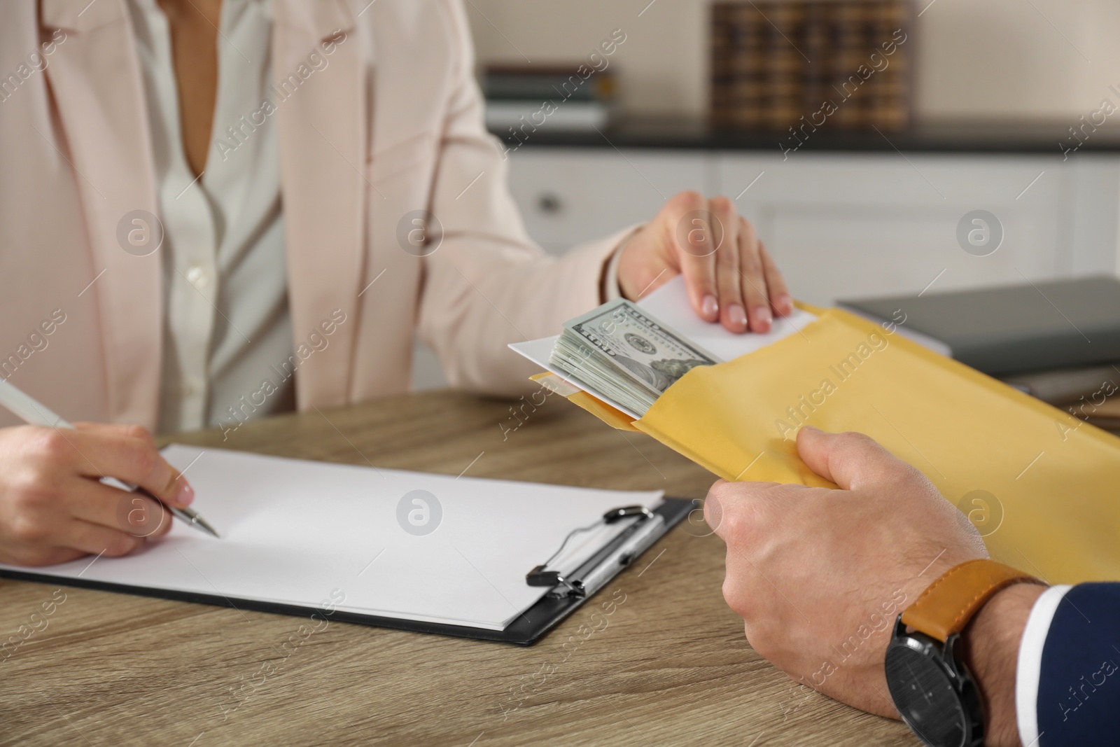 Photo of Man giving bribe to woman at table, closeup