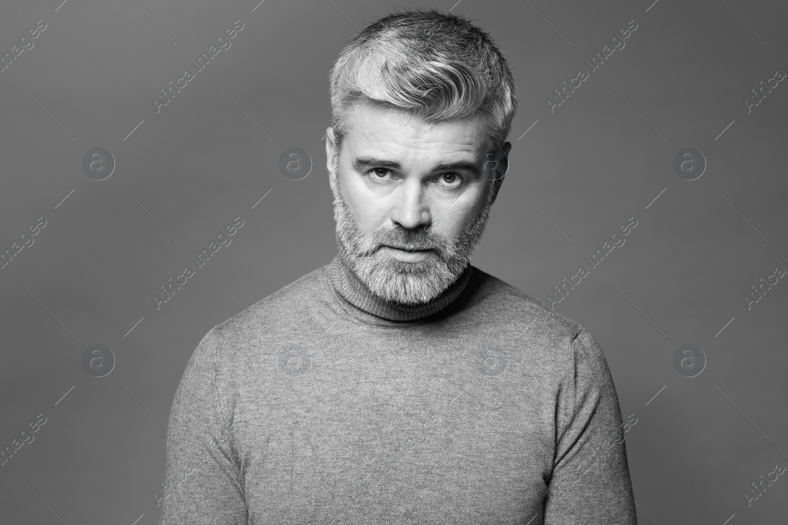 Photo of Portrait of handsome man on grey background. Black and white effect