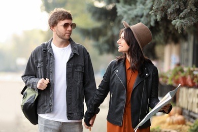 Photo of Couple of travelers with map on city street