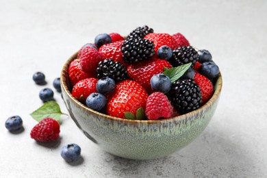Photo of Different fresh ripe berries on light grey table, closeup