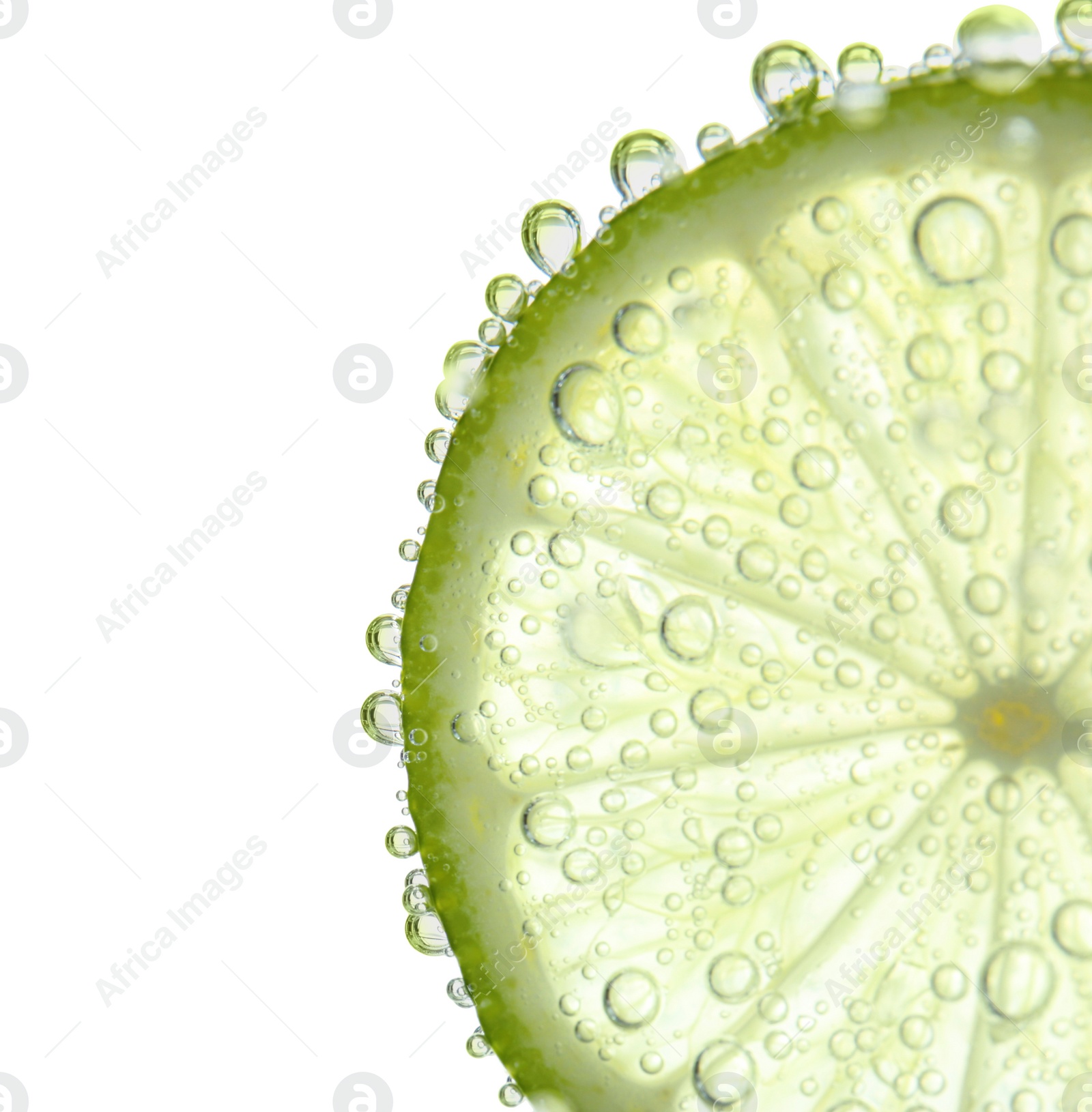 Photo of Fresh lime slice in sparkling water on white background, closeup