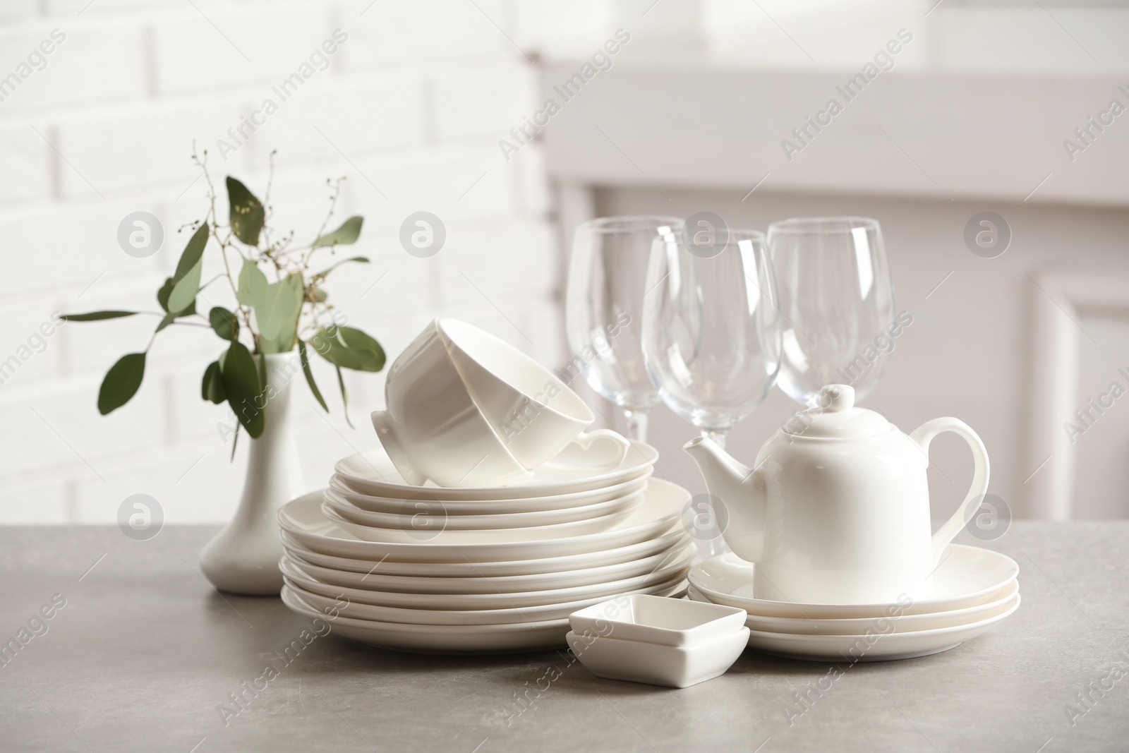 Photo of Set of clean dishes on table against blurred background