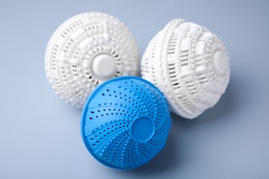 Photo of Dryer balls for washing machine on light grey background, closeup