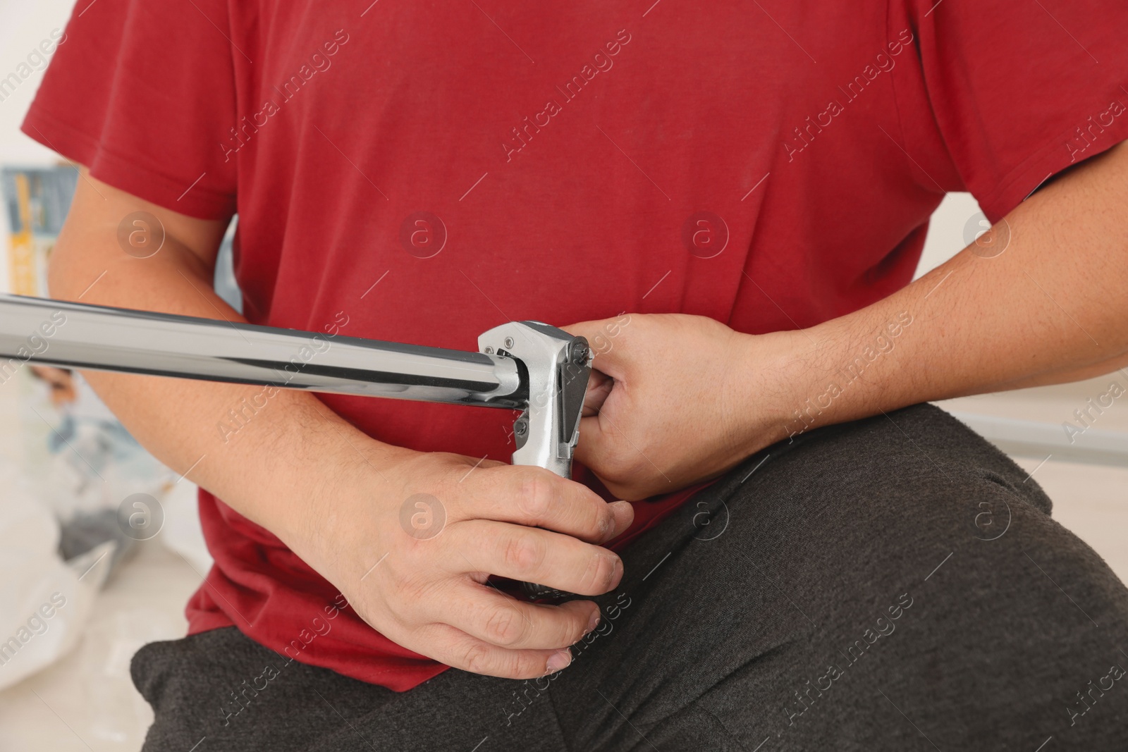 Photo of Worker installing new metal pipes indoors, closeup