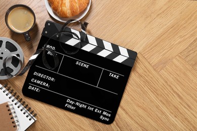 Photo of Flat lay composition with movie clapper on wooden table, space for text