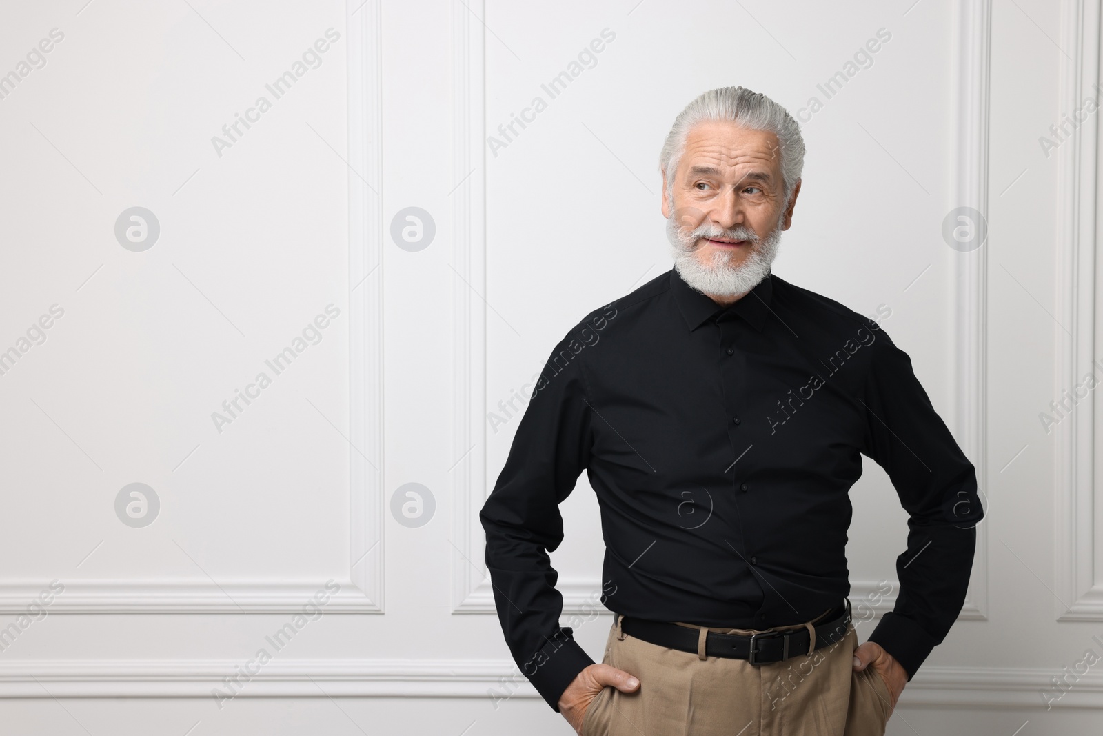 Photo of Portrait of handsome senior man near white wall. Space for text