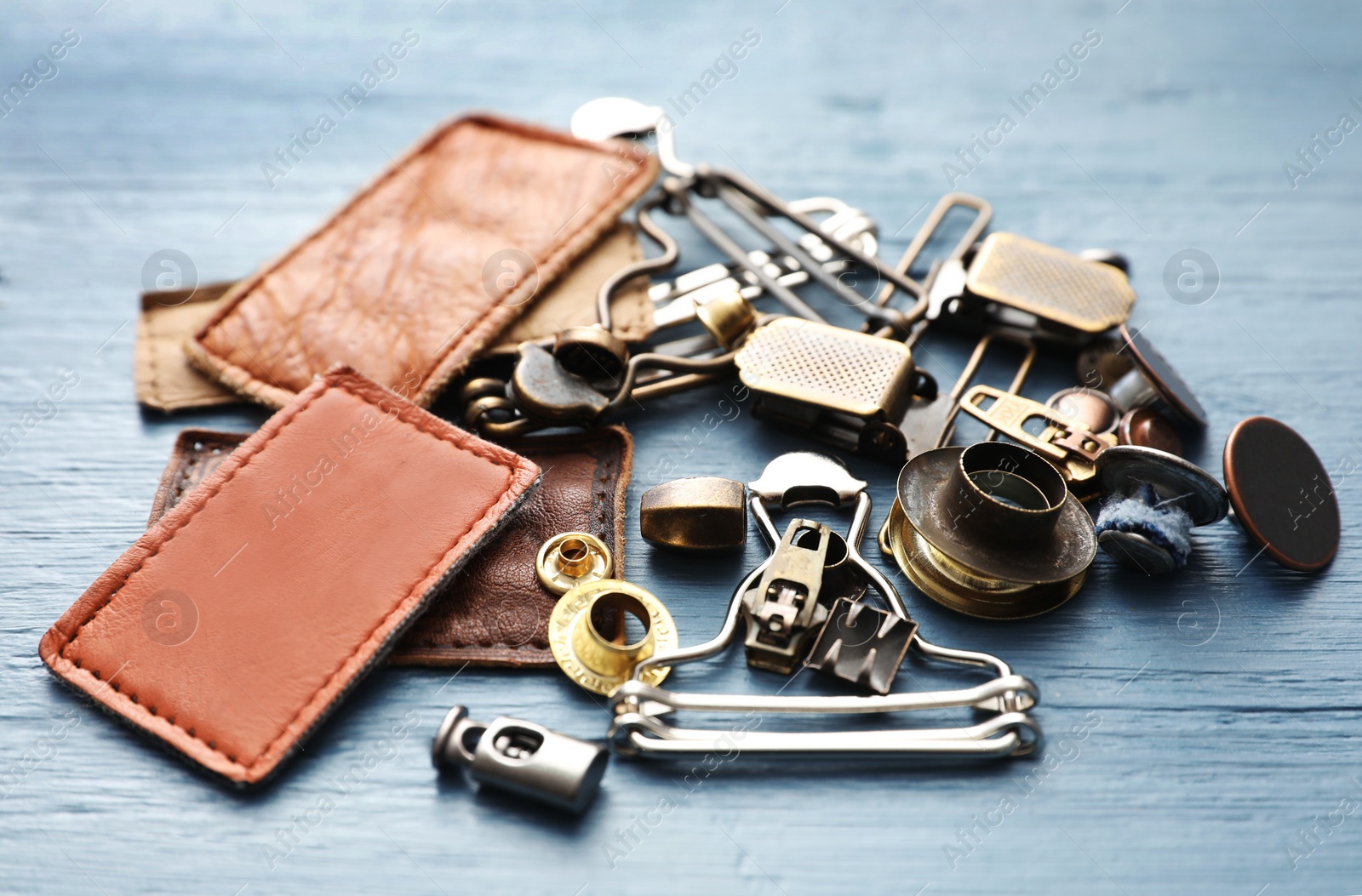 Photo of Composition with garment accessories for jeans on light blue wooden background