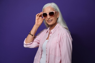 Portrait of beautiful mature woman on violet background