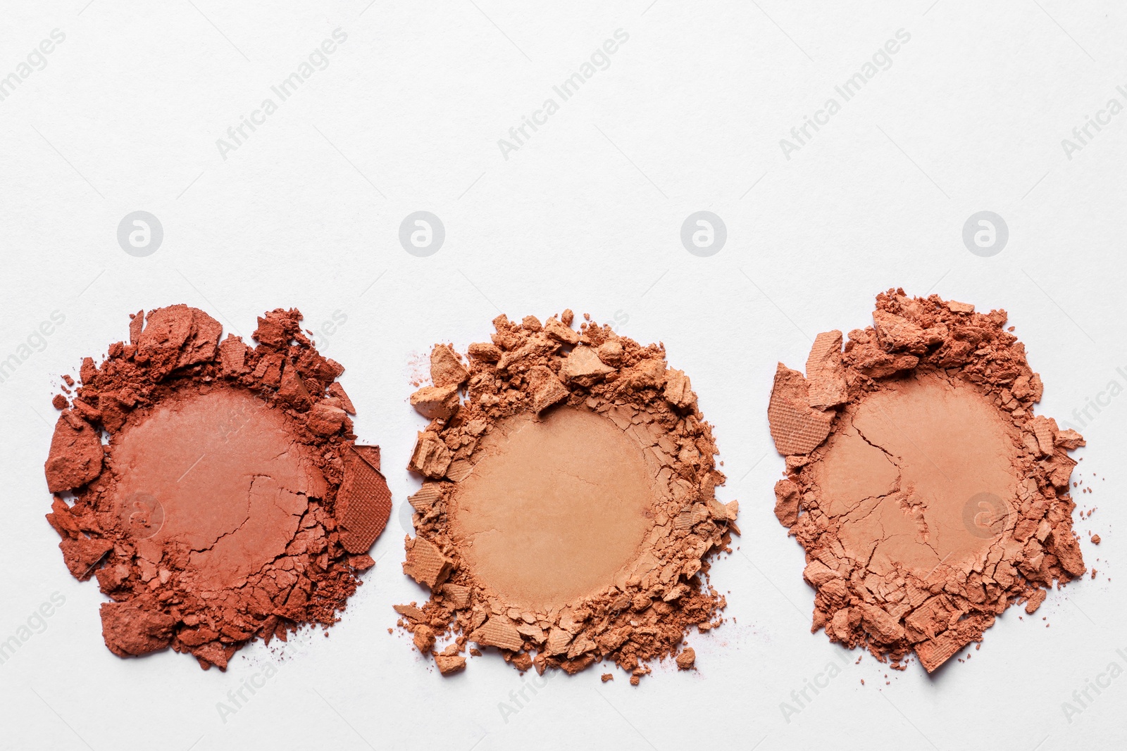 Photo of Different crushed eye shadows on white background, top view