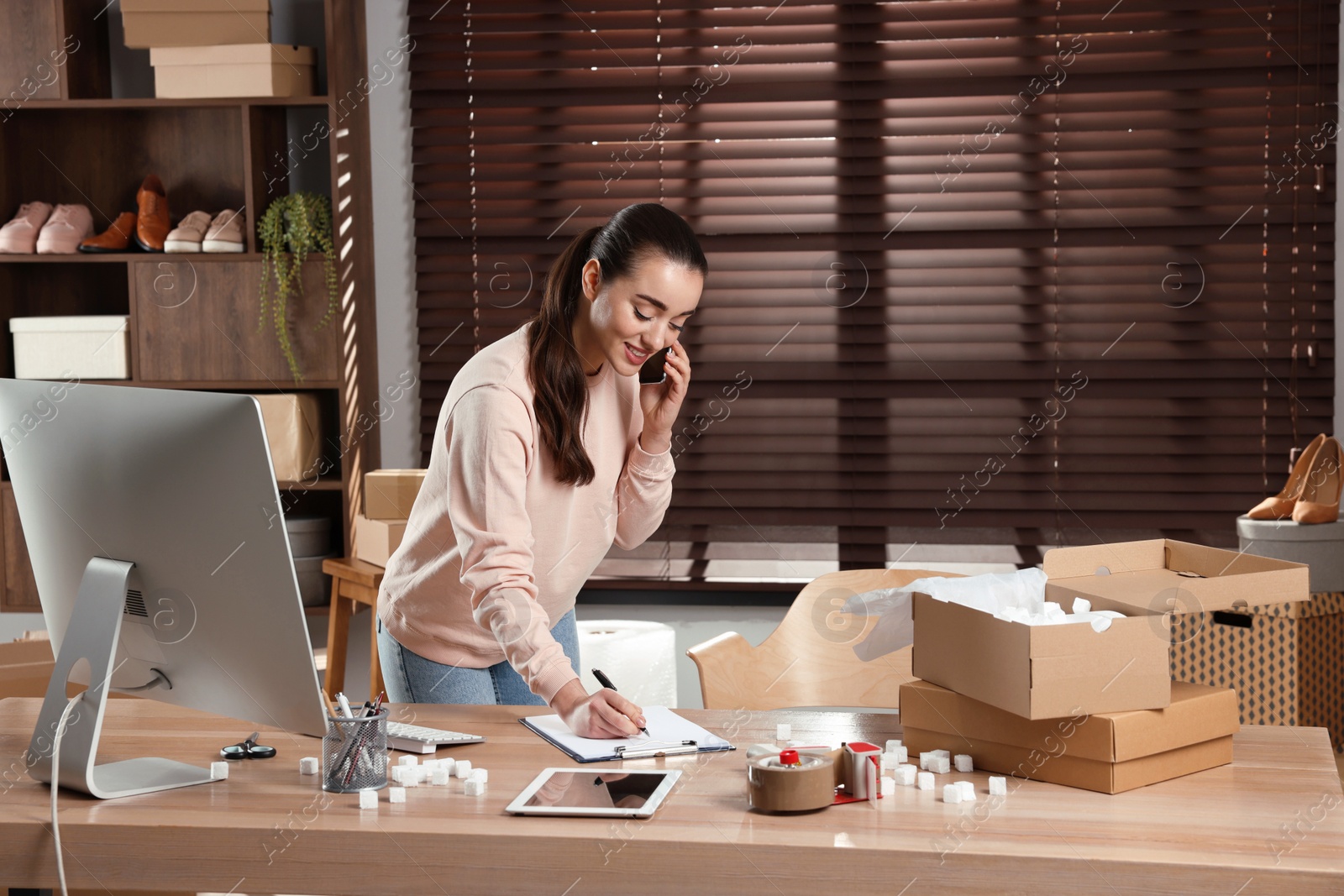 Photo of Seller talking on phone in office. Online store