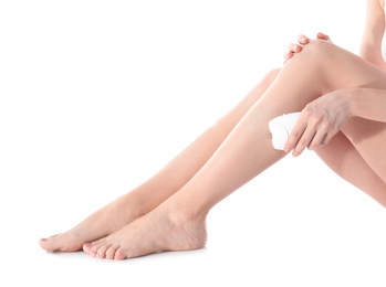 Photo of Young woman doing leg epilation procedure on white background, closeup