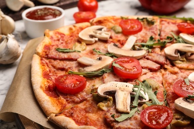 Hot delicious pizza baked in oven on table, closeup