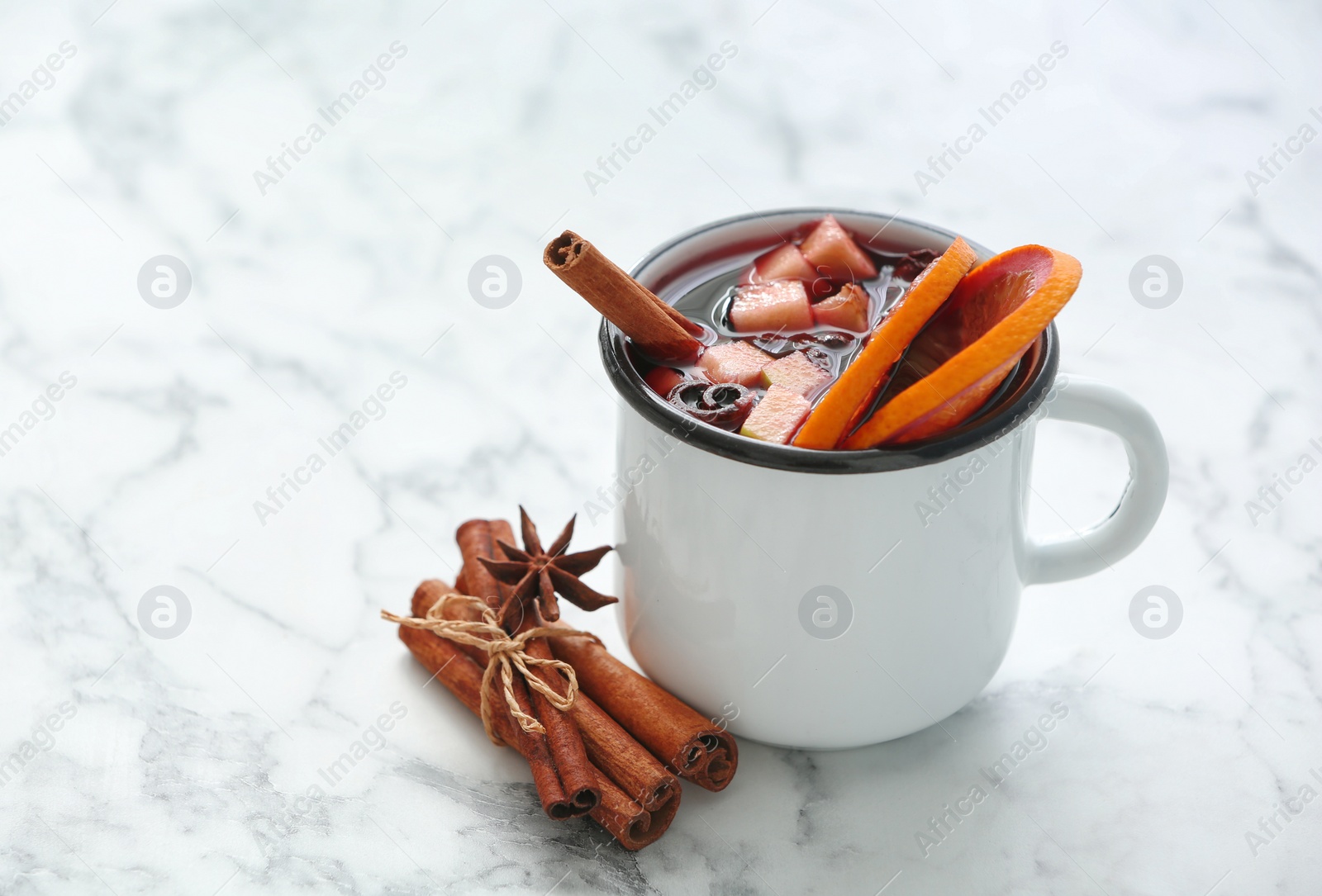 Photo of Mug with red mulled wine on marble table