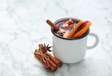 Photo of Mug with red mulled wine on marble table