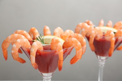 Photo of Shrimp cocktail with tomato sauce on light grey background, closeup