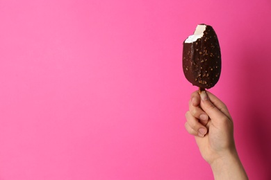 Photo of Woman holding delicious ice cream with chocolate against color background, space for text