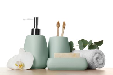 Bath accessories. Different personal care products, flower and eucalyptus branch on wooden table against white background