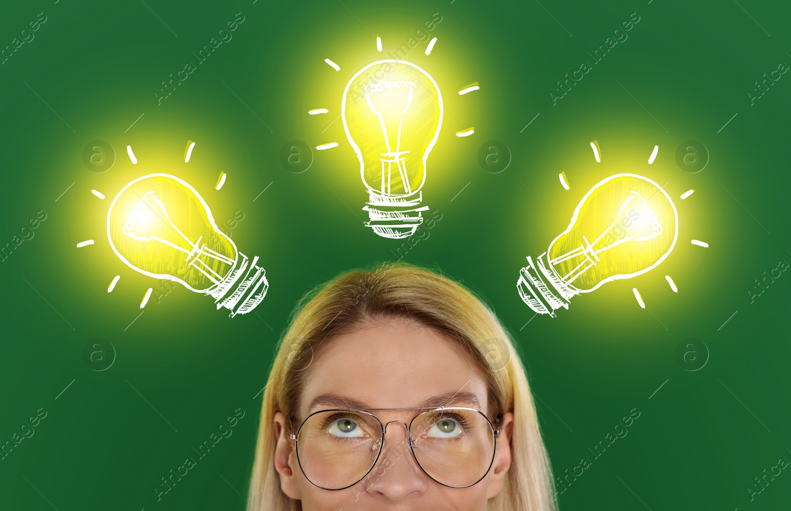 Image of Idea generation. Woman looking at illustrations of glowing light bulb over her on green background