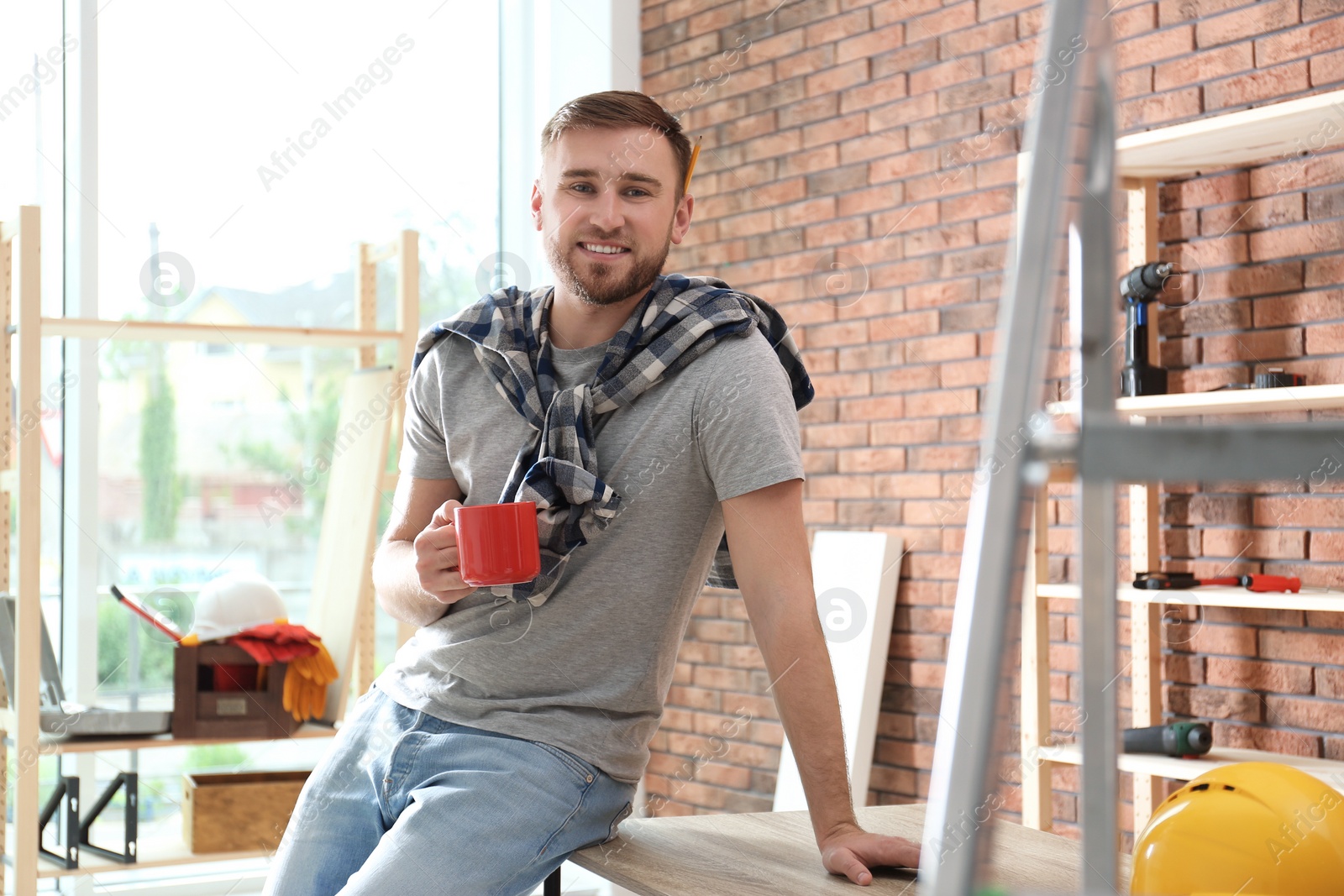 Photo of Young working man having coffee break indoors