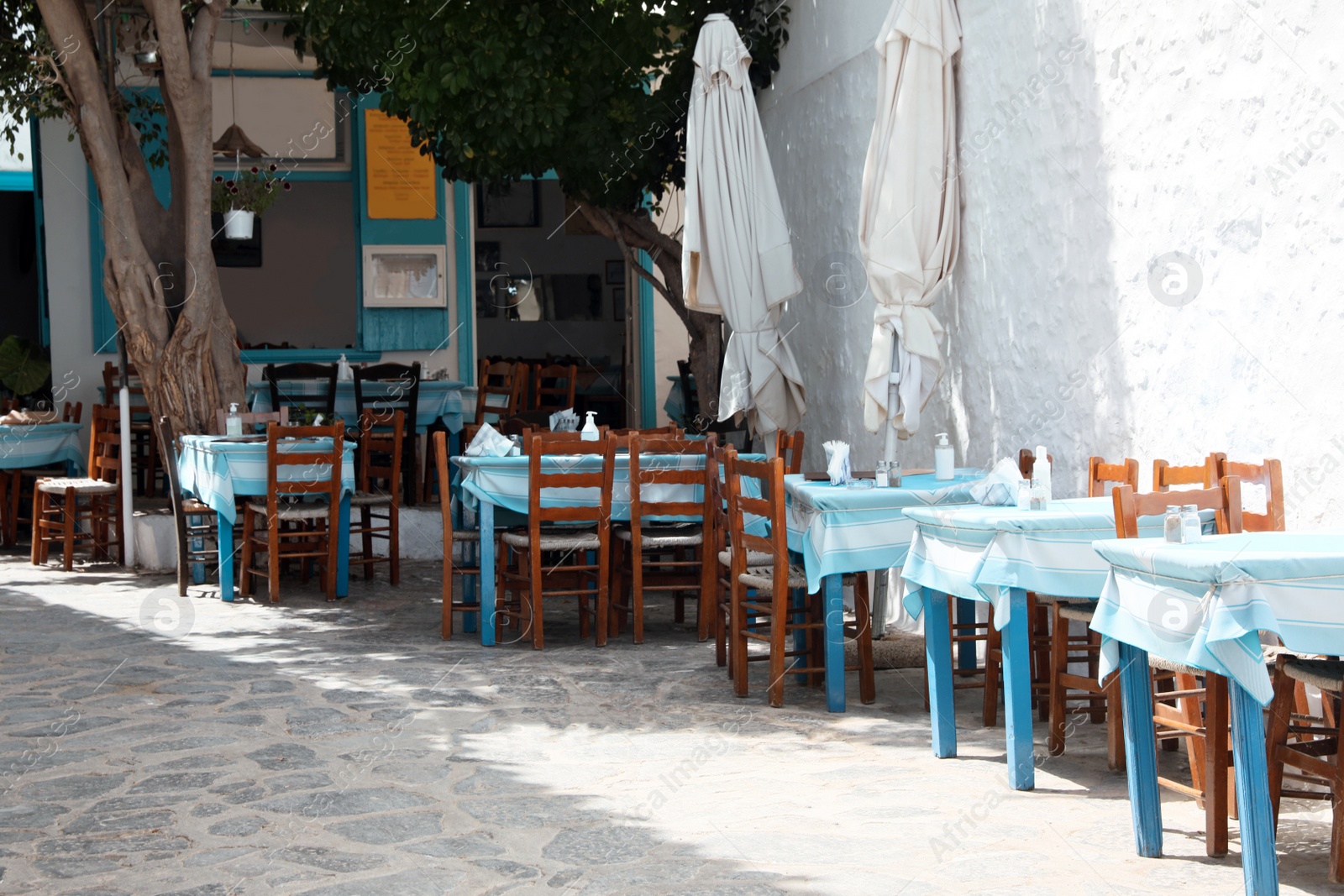 Photo of Beautiful outdoor cafe with wooden furniture on sunny day