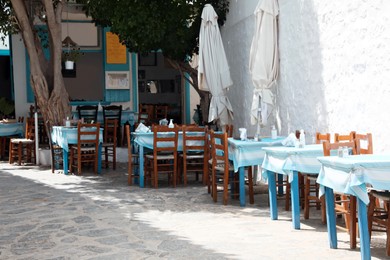 Beautiful outdoor cafe with wooden furniture on sunny day