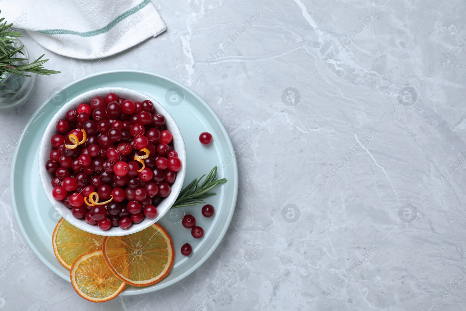 Photo of Flat lay composition with fresh ripe cranberries on grey table. Space for text