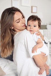 Photo of Mother hugging her cute little baby in room