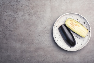 Photo of Plate with cut eggplant on grey background, top view