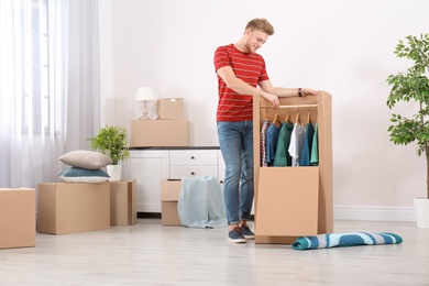 Young man near wardrobe box at home