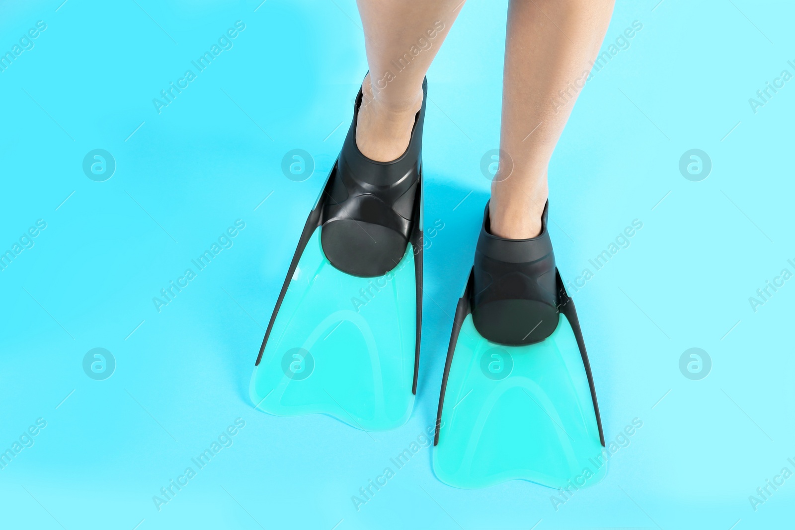 Photo of Woman in swimming flippers on color background, closeup