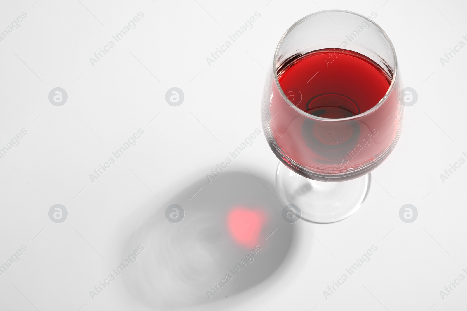 Photo of Tasty red wine in glass isolated on white, above view