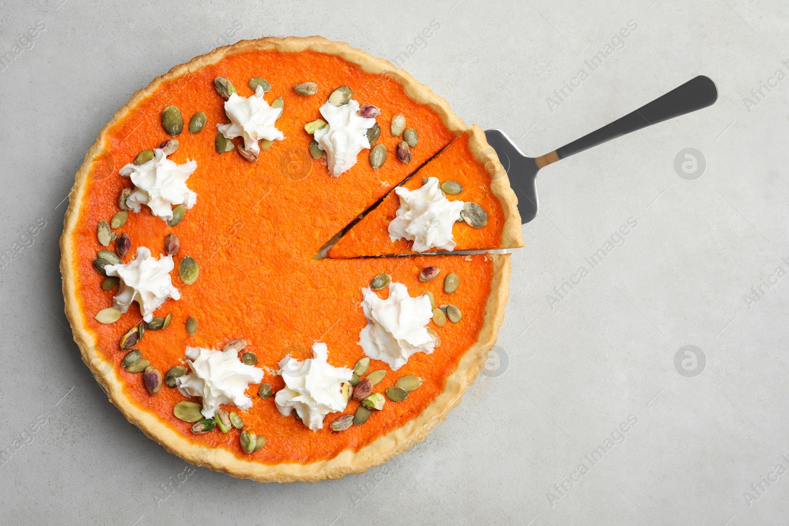 Photo of Delicious homemade pumpkin pie on light table, top view