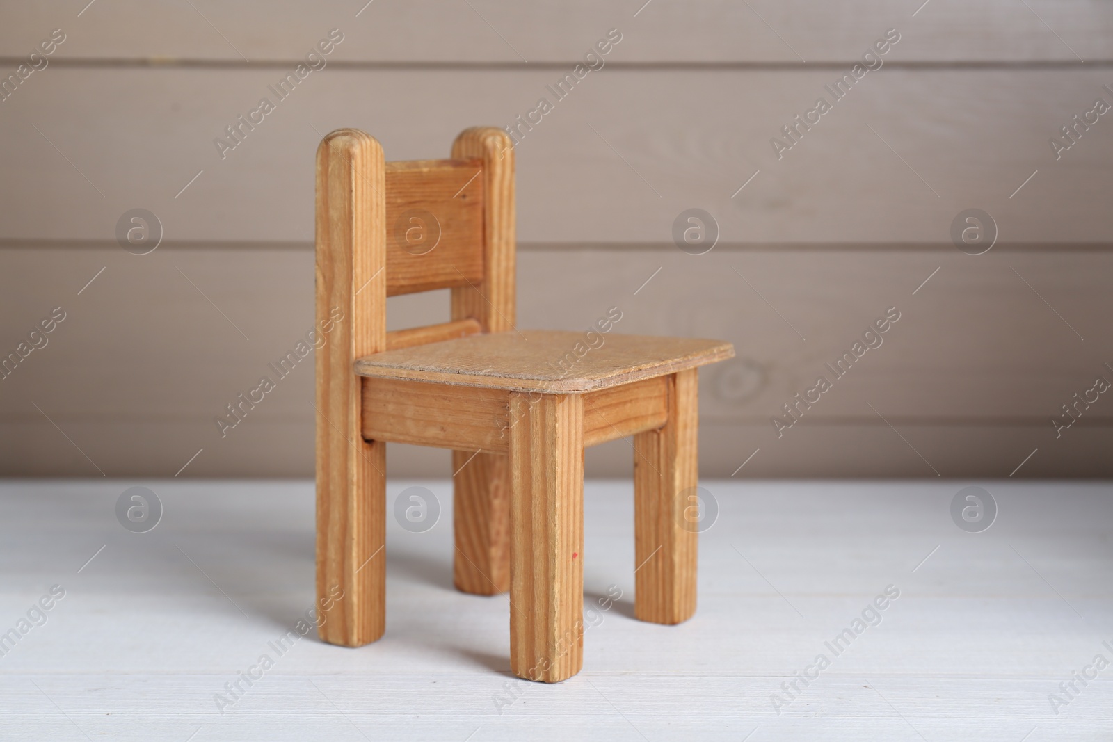 Photo of One small toy chair on white wooden table