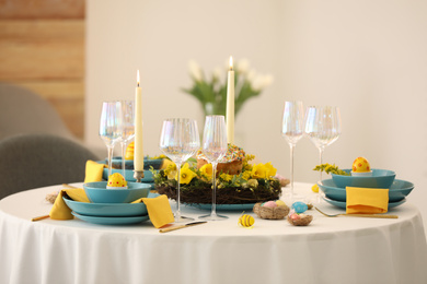 Festive Easter table setting with beautiful floral decor and eggs indoors