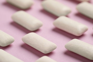 Photo of Many chewing gum pieces on pink background, closeup
