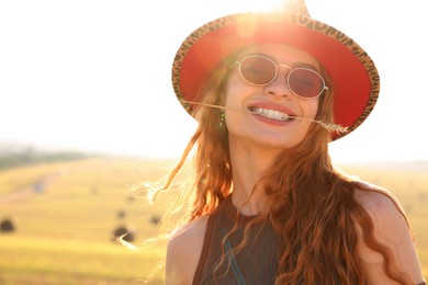 Beautiful happy hippie woman with spikelet in field, space for text