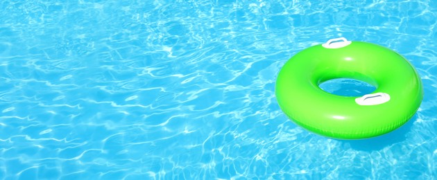 Inflatable ring floating in swimming pool on sunny day, space for text. Banner design