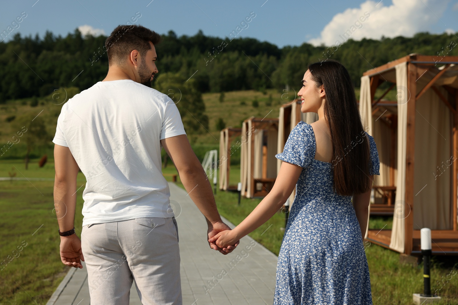 Photo of Romantic date. Beautiful couple walking on sunny day outdoors, back view