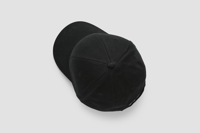 Stylish black baseball cap on white background, top view