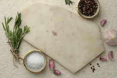 Photo of Cutting board, salt, pepper, rosemary and garlic on white textured table, flat lay. Space for text