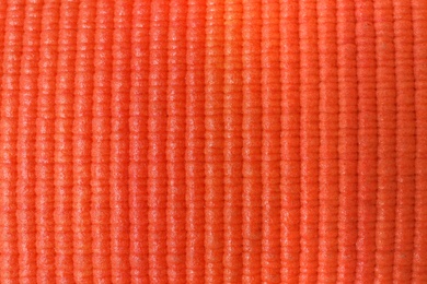 Photo of Orange foam rubber mat as background, top view