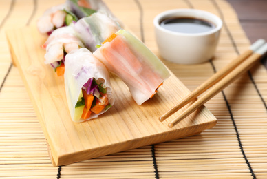 Photo of Delicious rolls wrapped in rice paper served on table