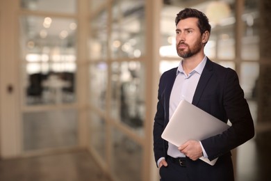 Successful lawyer with laptop on blurred background, space for text